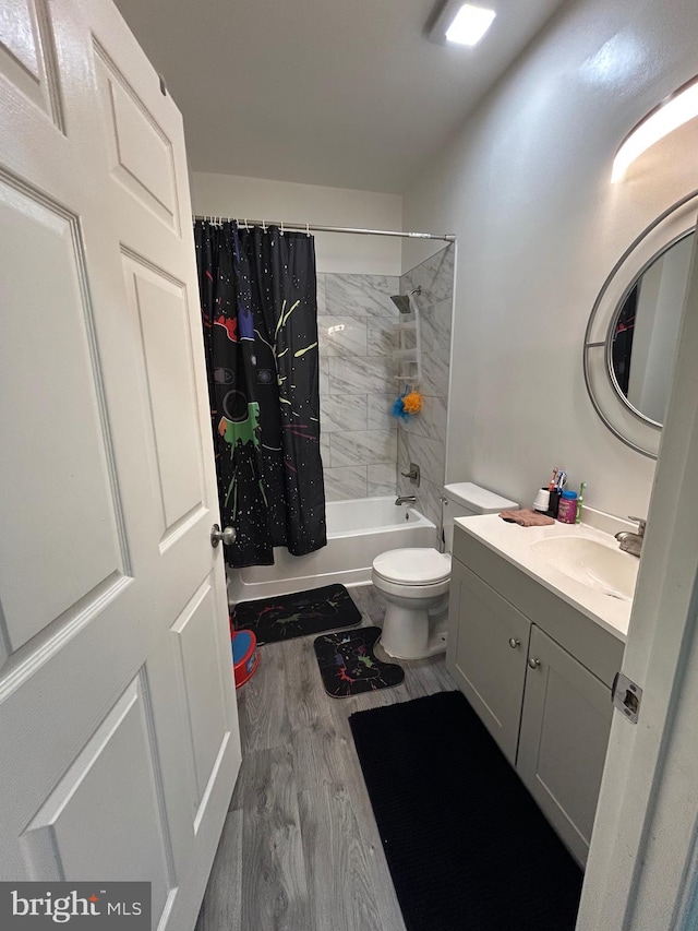 full bathroom with wood-type flooring, vanity, shower / tub combo, and toilet