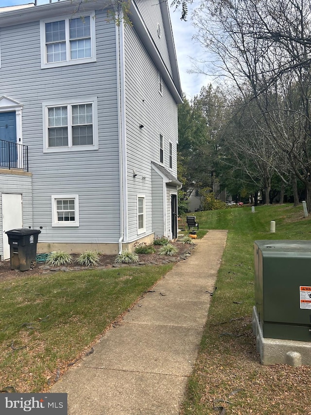 view of side of home with a balcony and a lawn