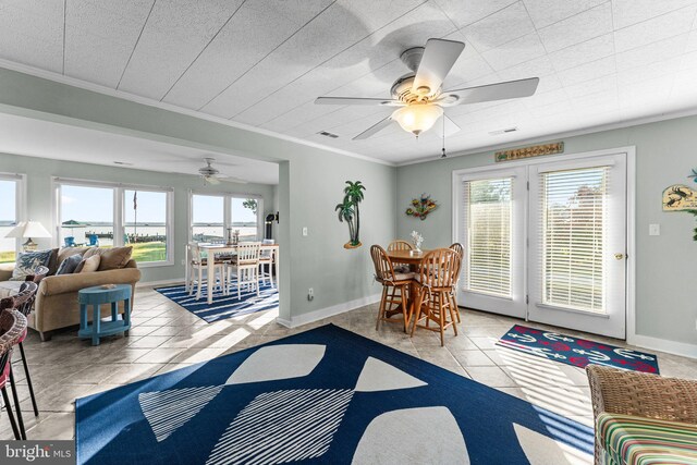 dining space with a wealth of natural light, ceiling fan, light tile patterned flooring, and crown molding