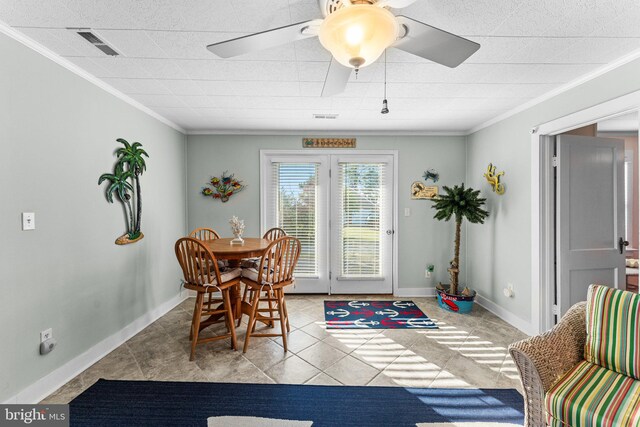 tiled dining space featuring crown molding and ceiling fan