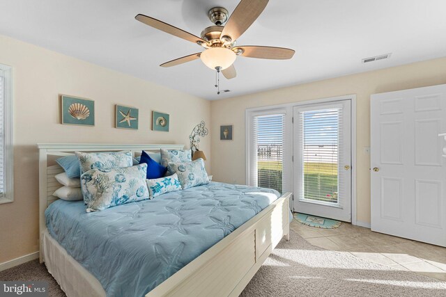 bedroom featuring access to outside, light tile patterned floors, and ceiling fan