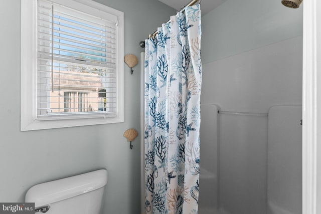 bathroom featuring a shower with curtain, a healthy amount of sunlight, and toilet