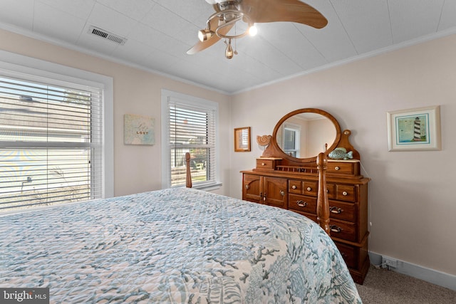 carpeted bedroom with ceiling fan and crown molding