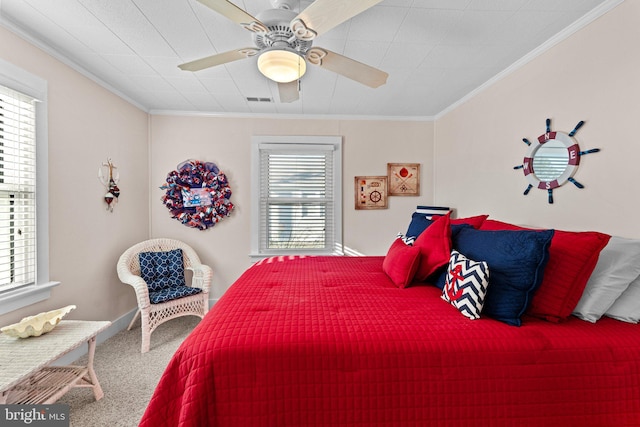 carpeted bedroom featuring ornamental molding and ceiling fan