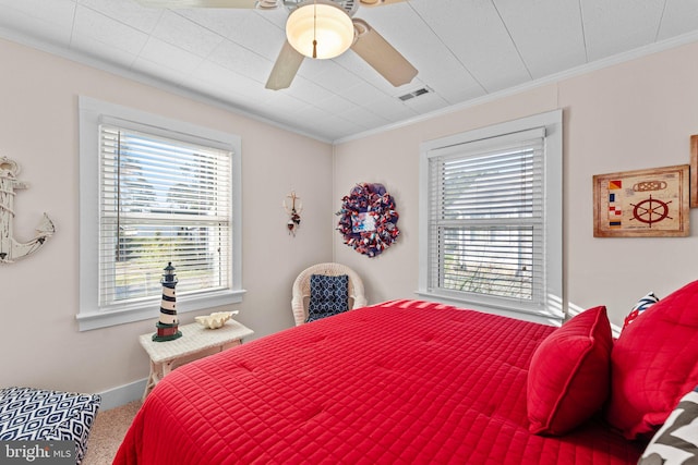 carpeted bedroom with crown molding and ceiling fan