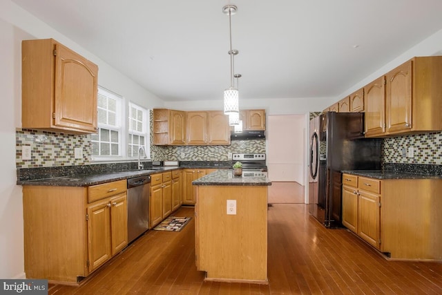 kitchen featuring hardwood / wood-style flooring, a kitchen island, decorative backsplash, stainless steel appliances, and decorative light fixtures