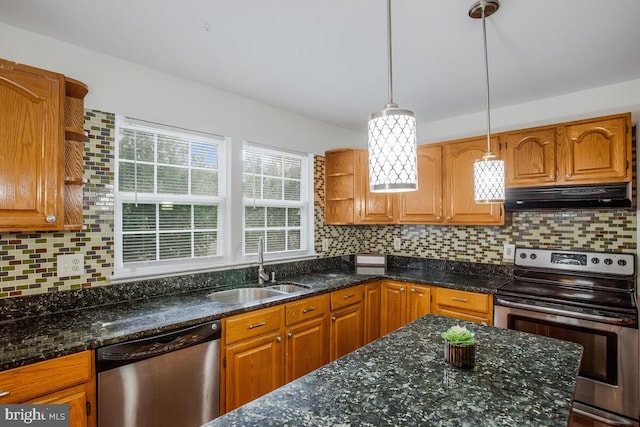 kitchen featuring decorative light fixtures, appliances with stainless steel finishes, sink, and decorative backsplash