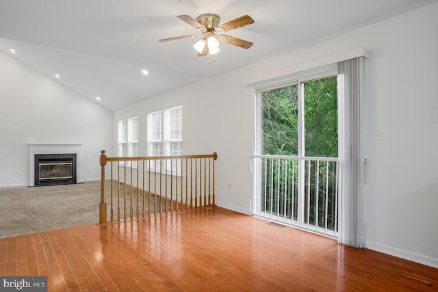 unfurnished living room with ceiling fan, hardwood / wood-style flooring, and lofted ceiling