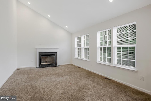 unfurnished living room with carpet and high vaulted ceiling