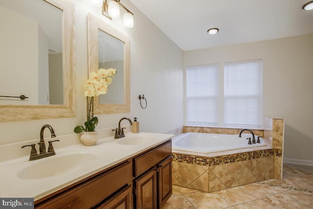 bathroom featuring tile patterned floors, tiled tub, and vanity