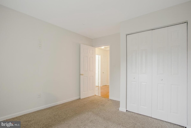 unfurnished bedroom with light carpet and a closet