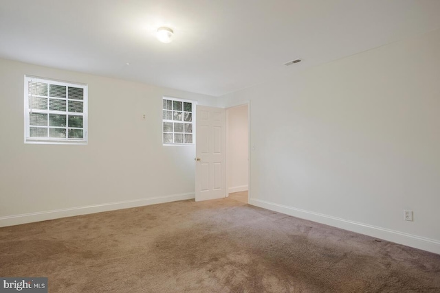 empty room with a healthy amount of sunlight and light carpet