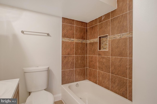 full bathroom with tiled shower / bath, vanity, and toilet