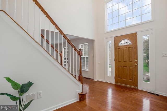 foyer with a high ceiling and hardwood / wood-style floors