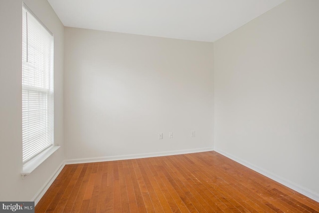 unfurnished room with a wealth of natural light and hardwood / wood-style floors