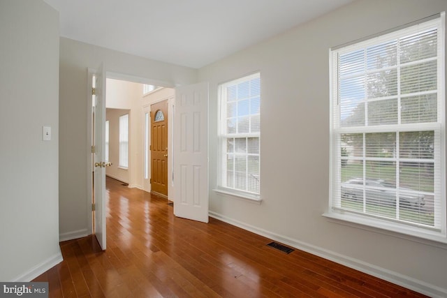 spare room featuring hardwood / wood-style flooring and a wealth of natural light