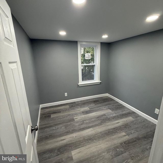 unfurnished room with dark wood-type flooring