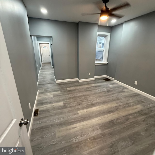 unfurnished room with dark wood-type flooring and ceiling fan