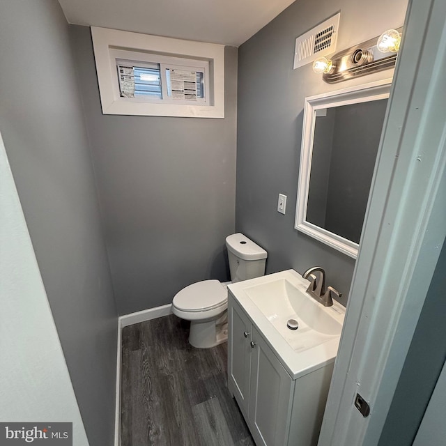 bathroom featuring toilet, vanity, and wood-type flooring