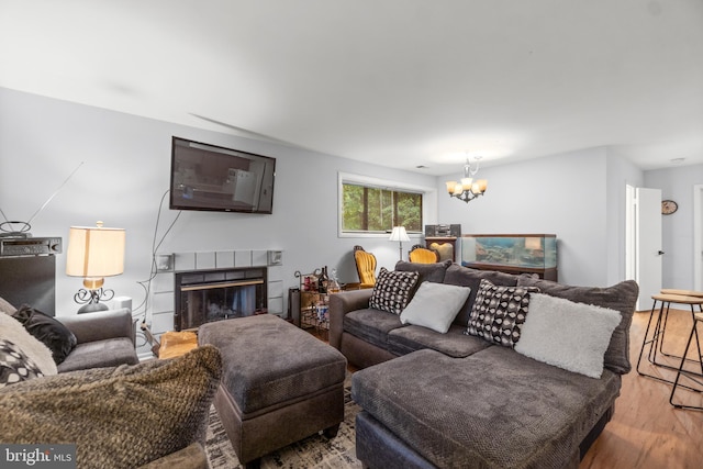 living room with wood-type flooring and a tiled fireplace