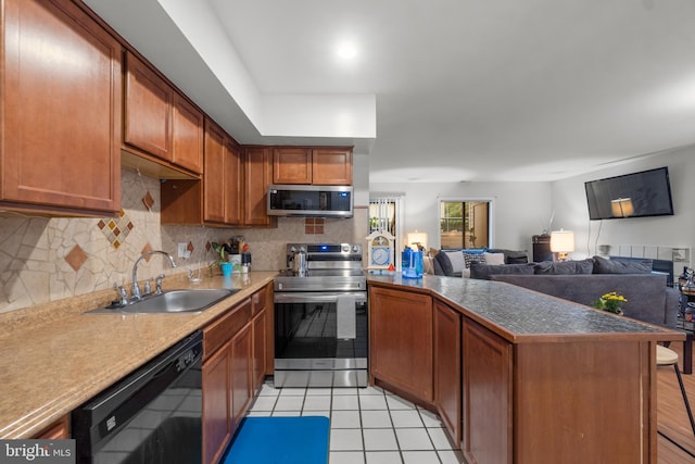 kitchen with light tile patterned floors, sink, backsplash, stainless steel appliances, and a breakfast bar