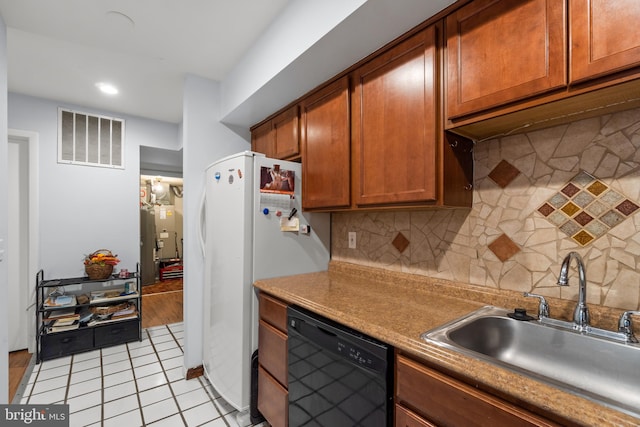 kitchen featuring dishwasher, sink, white fridge, backsplash, and light tile patterned floors