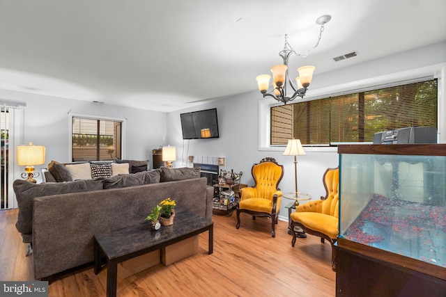 living room with a notable chandelier and light hardwood / wood-style floors