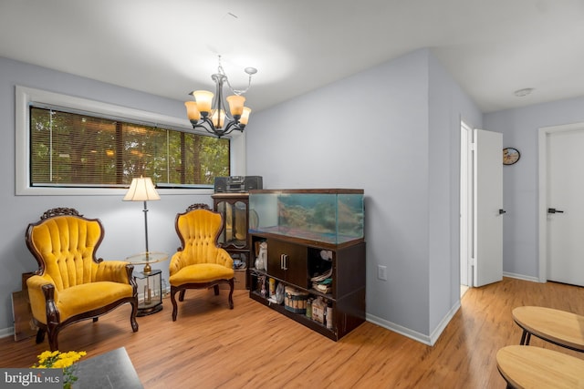 living area with a notable chandelier and light hardwood / wood-style flooring