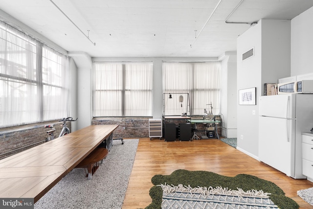 home office with light hardwood / wood-style floors