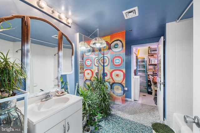 bathroom with vanity and tiled shower / bath