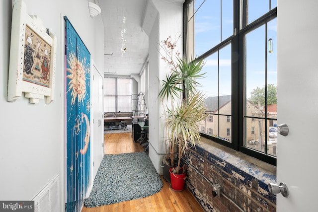 corridor with expansive windows and hardwood / wood-style floors