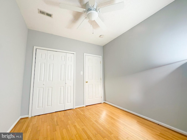 unfurnished bedroom with ceiling fan and hardwood / wood-style flooring