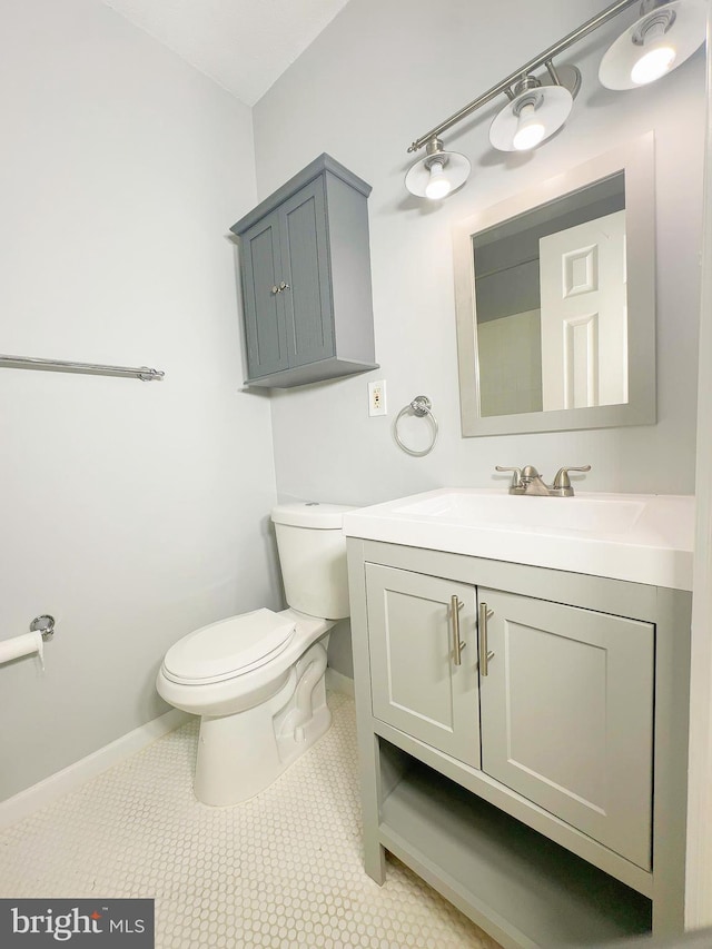 bathroom with toilet, tile patterned flooring, and vanity