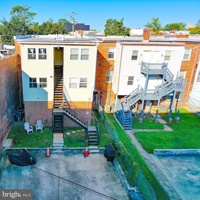 rear view of house featuring a yard and central AC