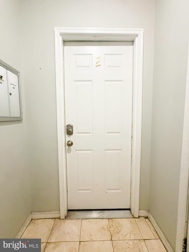 doorway to outside featuring mail boxes and light tile patterned floors