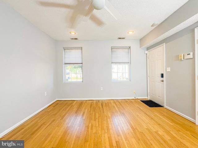 interior space featuring ceiling fan, a textured ceiling, hardwood / wood-style floors, and a wealth of natural light