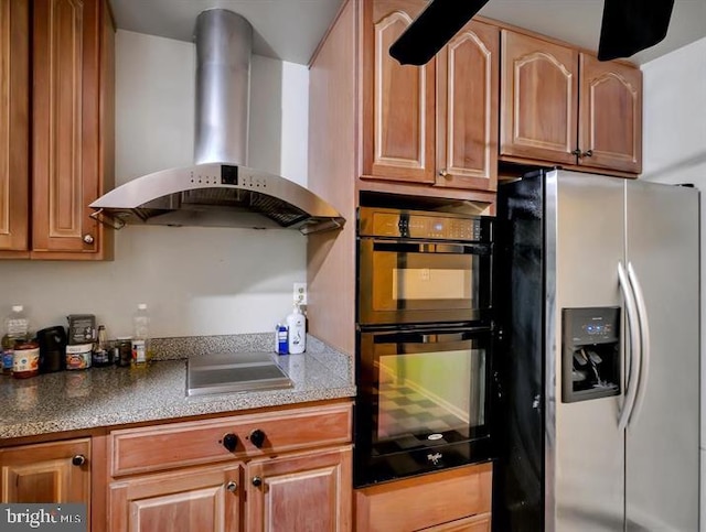 kitchen with wall chimney exhaust hood and stainless steel appliances