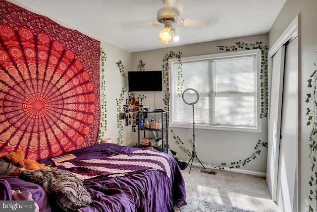 carpeted bedroom featuring ceiling fan and a closet