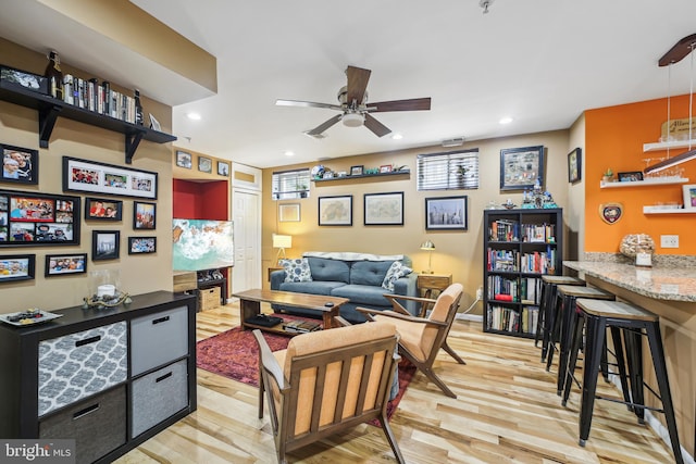 living room featuring light wood-type flooring and ceiling fan