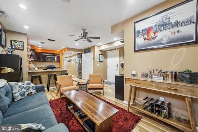 living room with ceiling fan and light hardwood / wood-style floors