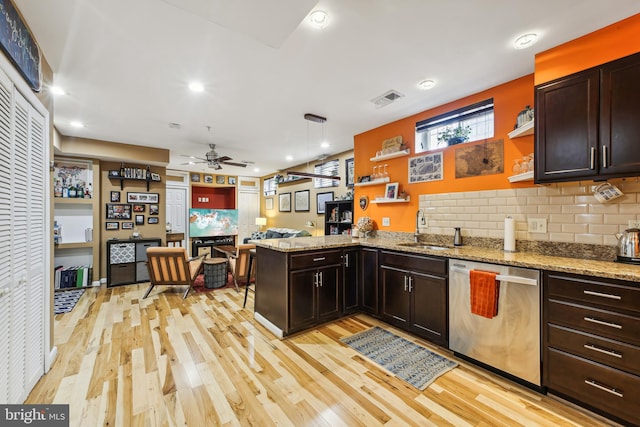 kitchen with pendant lighting, dishwasher, sink, kitchen peninsula, and light hardwood / wood-style flooring