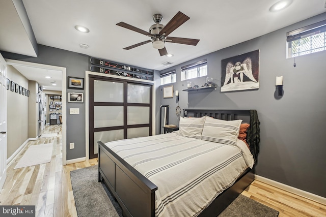 bedroom featuring wood-type flooring, multiple windows, and ceiling fan