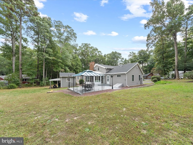 back of house with a yard and a patio