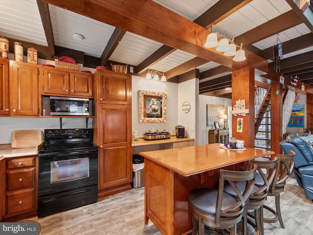 kitchen featuring black range with electric stovetop, beamed ceiling, light hardwood / wood-style flooring, and a breakfast bar