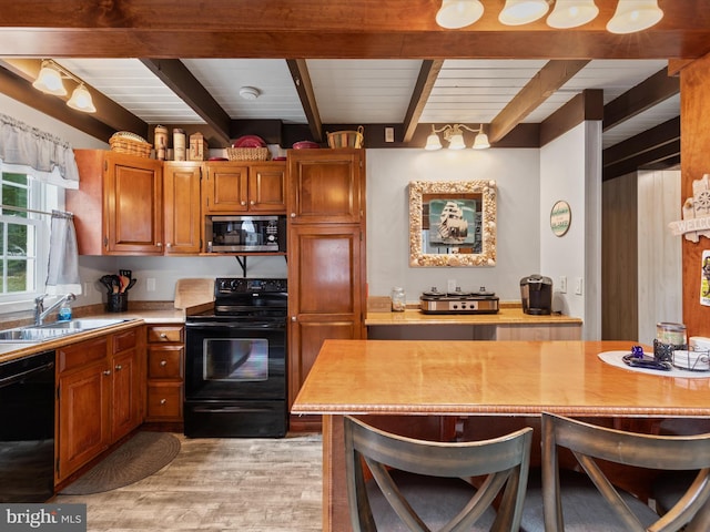 kitchen with light hardwood / wood-style floors, beamed ceiling, sink, black appliances, and a kitchen bar