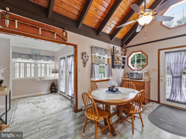 dining room featuring ceiling fan, beam ceiling, light hardwood / wood-style flooring, and a healthy amount of sunlight