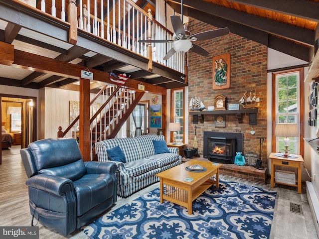 living room with high vaulted ceiling, beam ceiling, and light hardwood / wood-style flooring