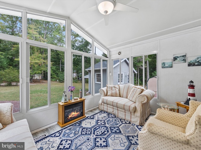 sunroom / solarium with ceiling fan, a wealth of natural light, and vaulted ceiling