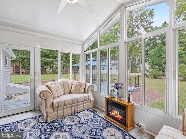 sunroom / solarium with ceiling fan, vaulted ceiling, and a healthy amount of sunlight