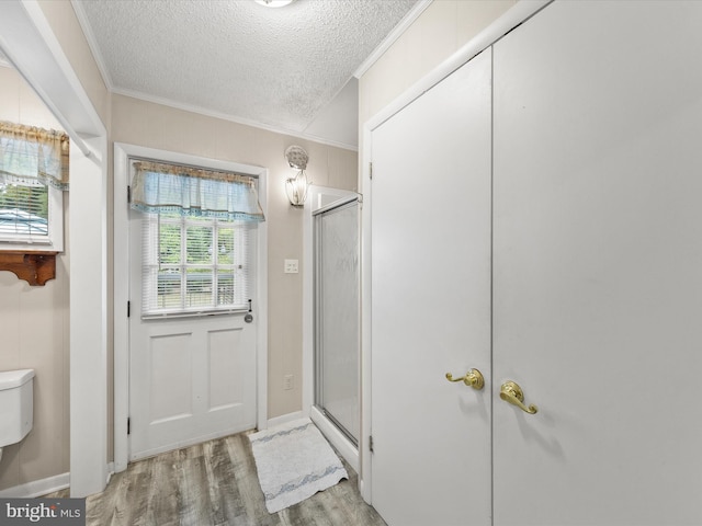 bathroom featuring a textured ceiling, crown molding, hardwood / wood-style floors, and a wealth of natural light